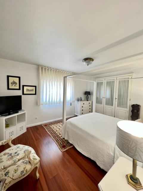 阿尔科巴萨Cocas House - Alcobaça的一间白色卧室,配有床和电视