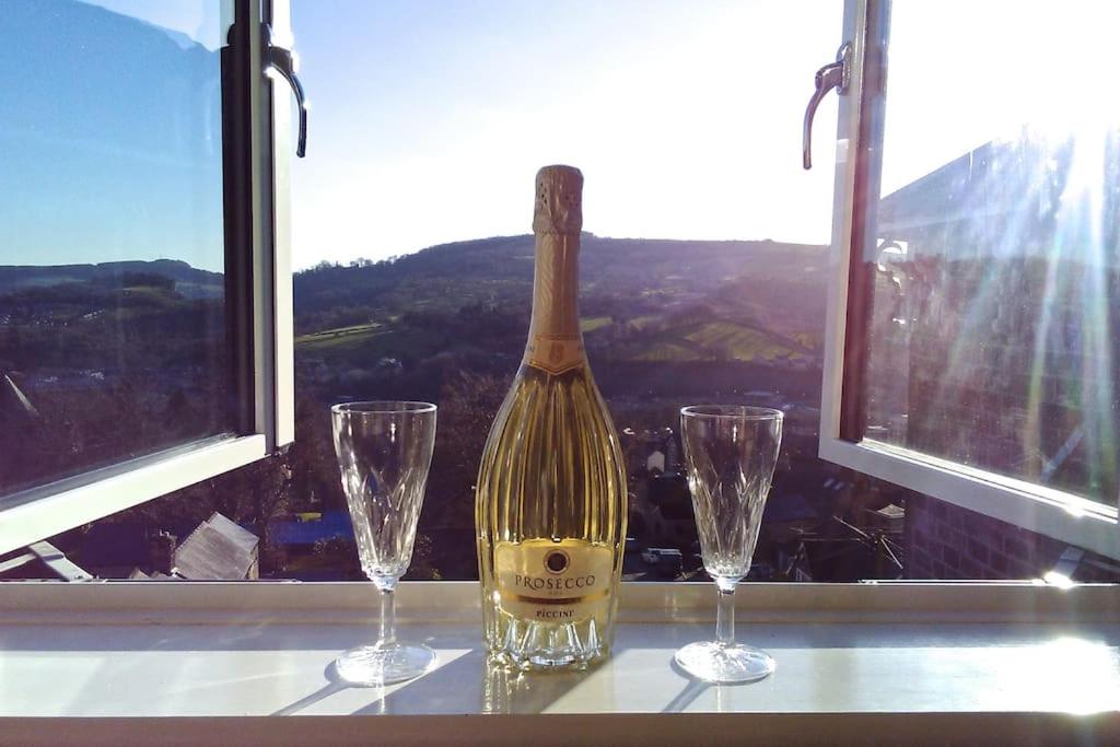 马特洛克Birds Nest, Romantic getaway with stunning views的一张桌子上放着一瓶葡萄酒,放上两杯
