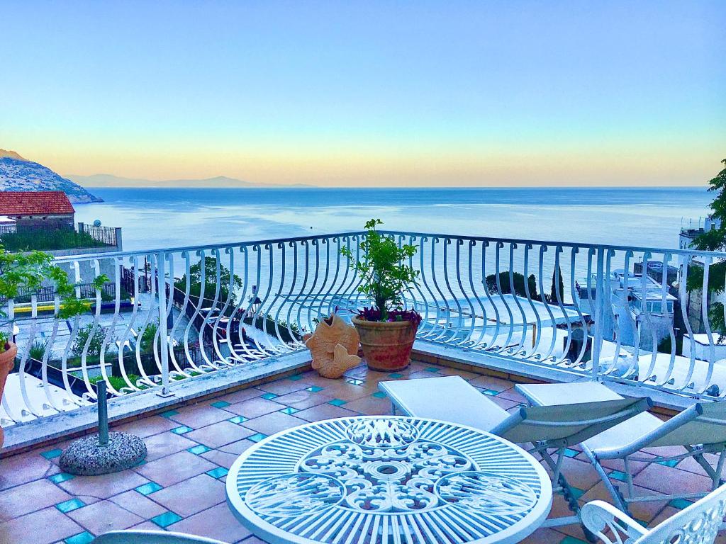 波西塔诺Hotel Villa Delle Palme in Positano的一个带桌椅的庭院和大海