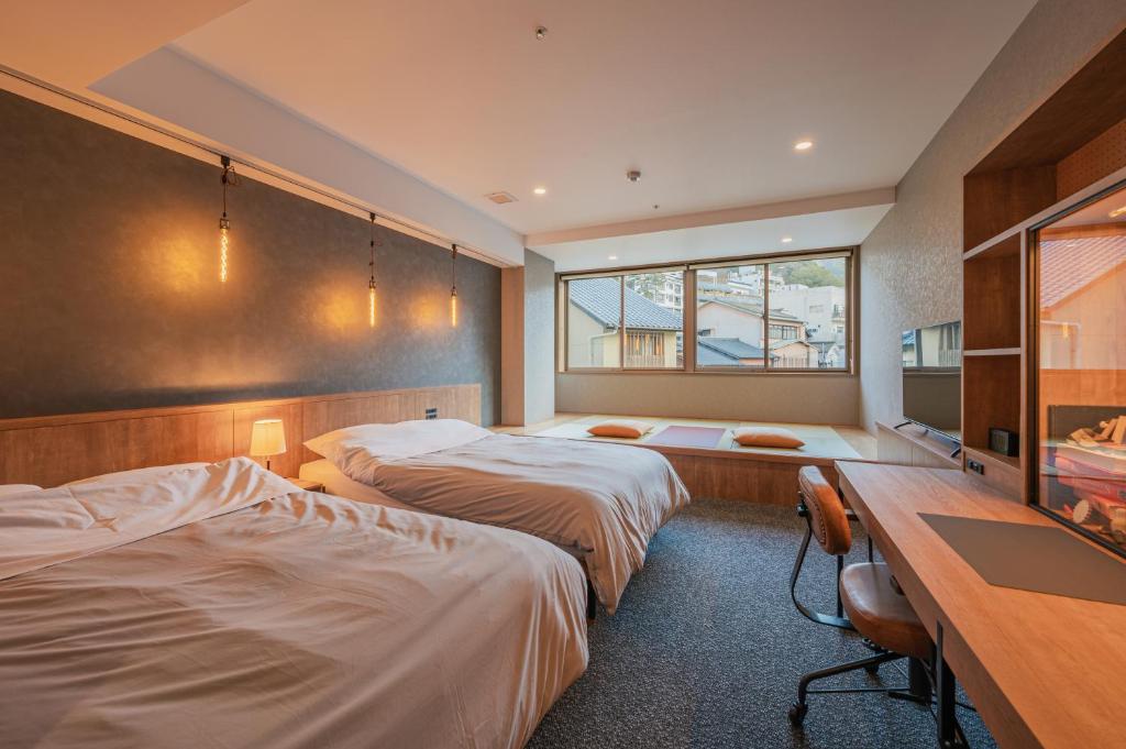 神户HOTEL ALGO的酒店客房配有两张床和一张书桌
