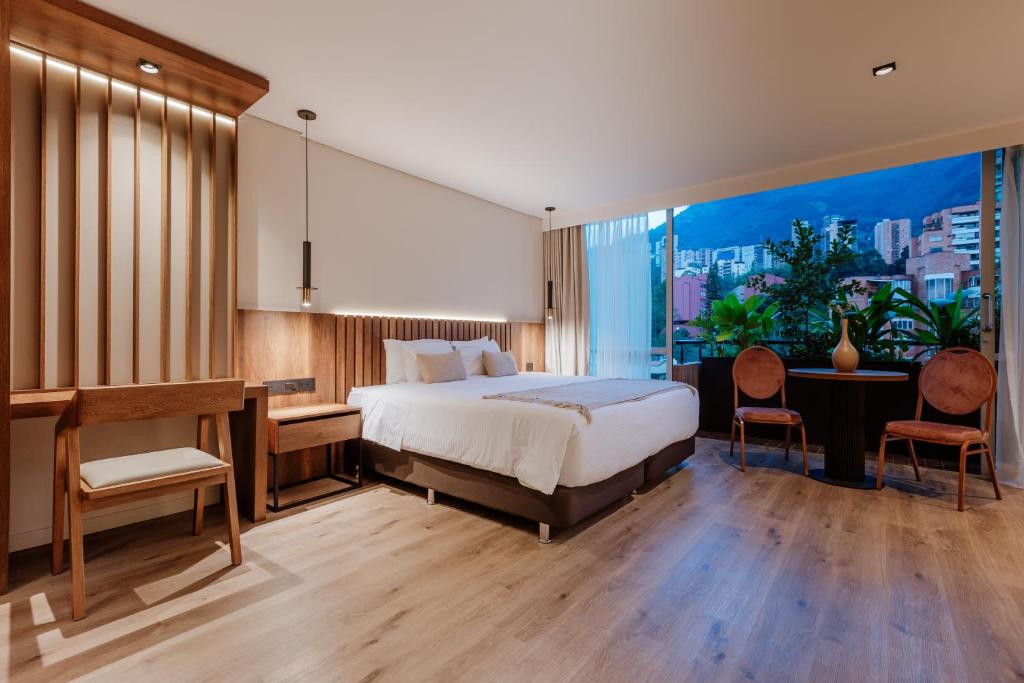 麦德林1616 Hotel Medellin的酒店客房配有一张床、一张书桌和一张书桌。