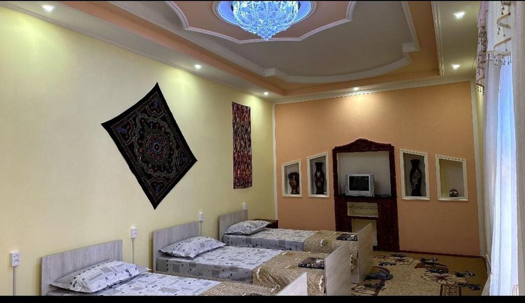 布哈拉Orzu Guest House的一间设有三张床的客房,设有天花板
