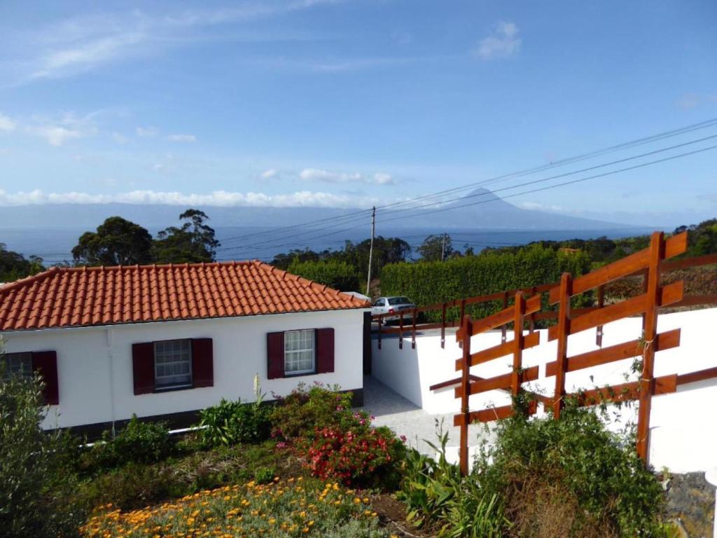 UrzelinaAzorean Cottage São Jorge的白色的房子,有红色的屋顶和栅栏