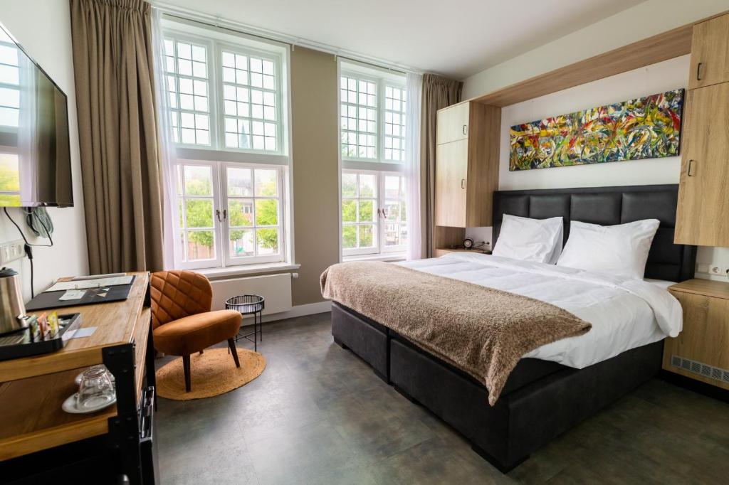 纳尔德韦克Hotel Inn Naeldwyk的卧室配有一张床、一张书桌和窗户。