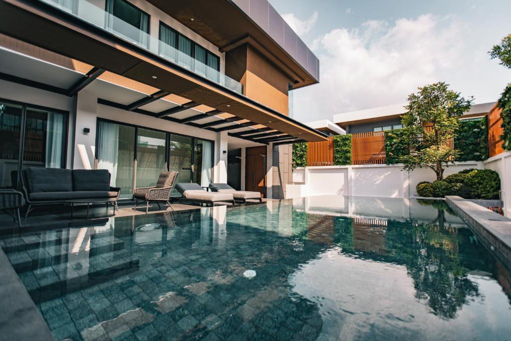 农布Astro Luxury: Ultra Luxury 4 Beds Pool Villa的房屋前的游泳池