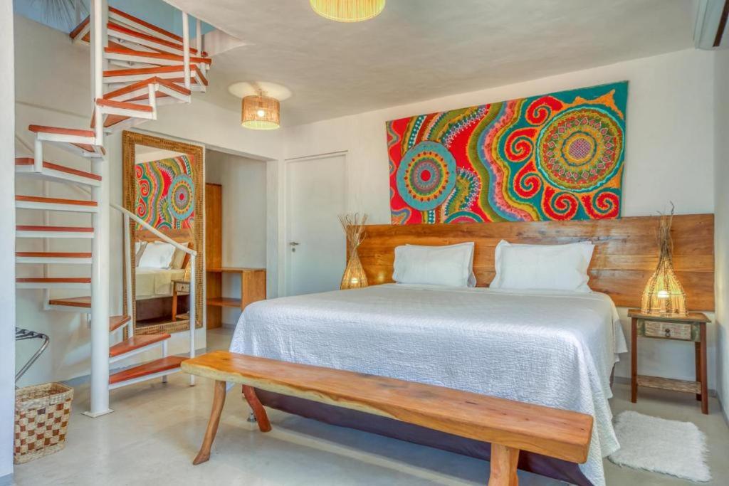 佩德拉斯港Pousada Rota Ecológica的一间卧室配有一张带长凳和绘画的床