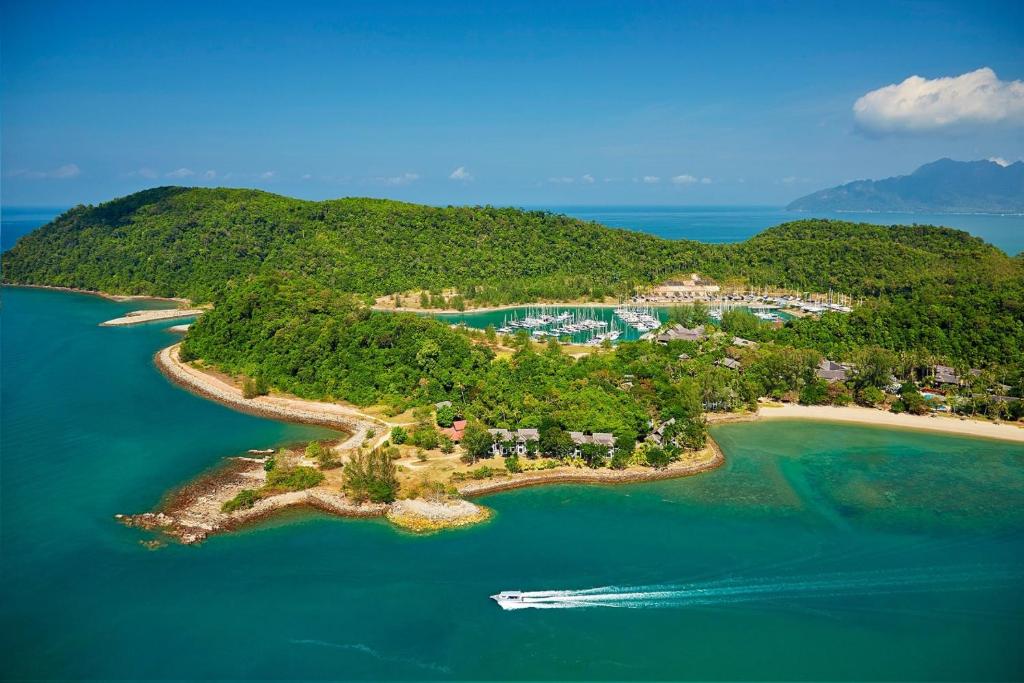 珍南海滩Rebak Island Resort & Marina, Langkawi的海中的一个岛屿,在水中划船