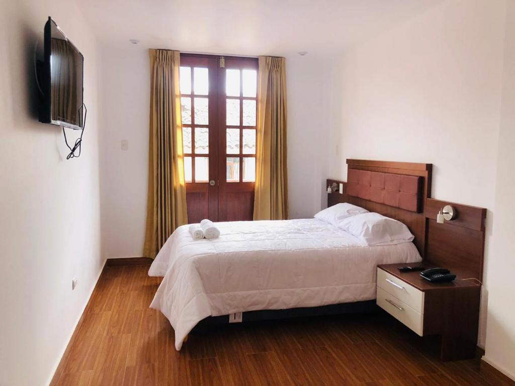 卡哈马卡Hotel Silva Inn的一间卧室配有一张大床和电视