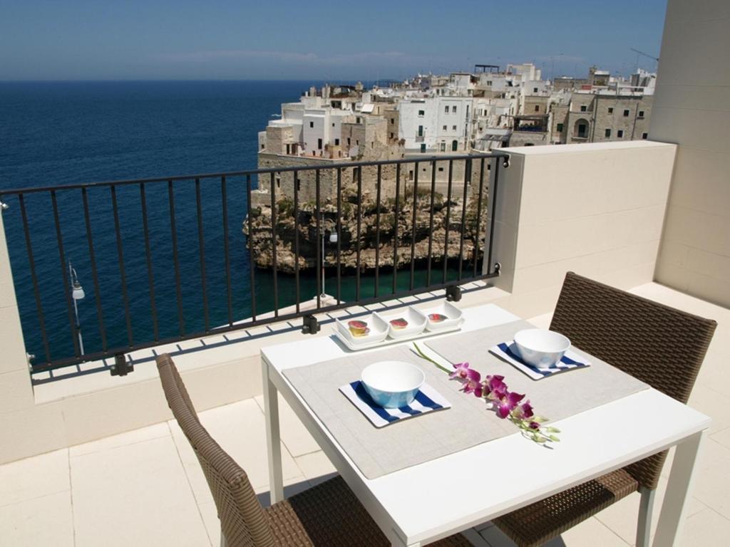 滨海波利尼亚诺马陆住宿加早餐酒店的阳台上配有白色的桌椅,享有海景