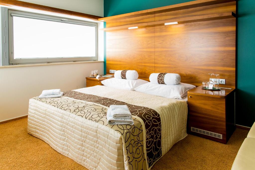 布尔诺内姆阿尔什时尚餐饮酒店的一间卧室设有一张大床和一个窗户。