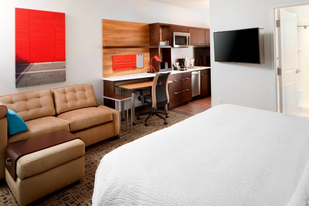 哥伦布TownePlace Suites by Marriott Columbus Easton Area的酒店客房配有一张床、一张书桌和一张沙发。