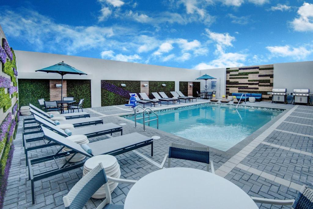 迈阿密迈阿密机场万豪广场套房酒店 的一个带躺椅和桌子的游泳池