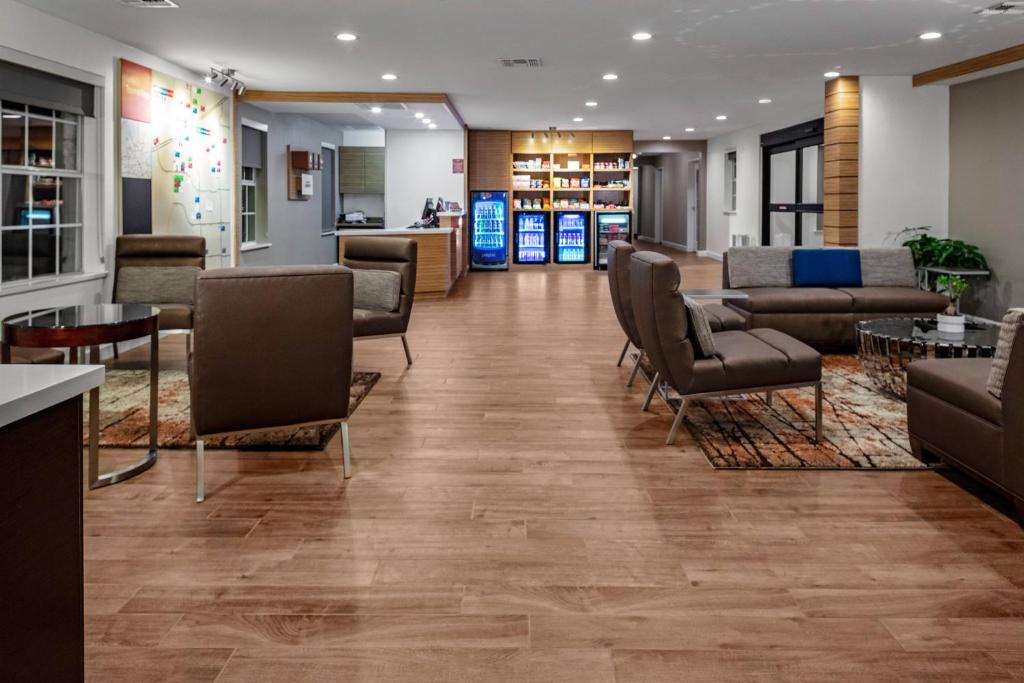 普莱诺TownePlace Suites by Marriott Dallas Plano/Legacy的医院的大厅,有桌椅
