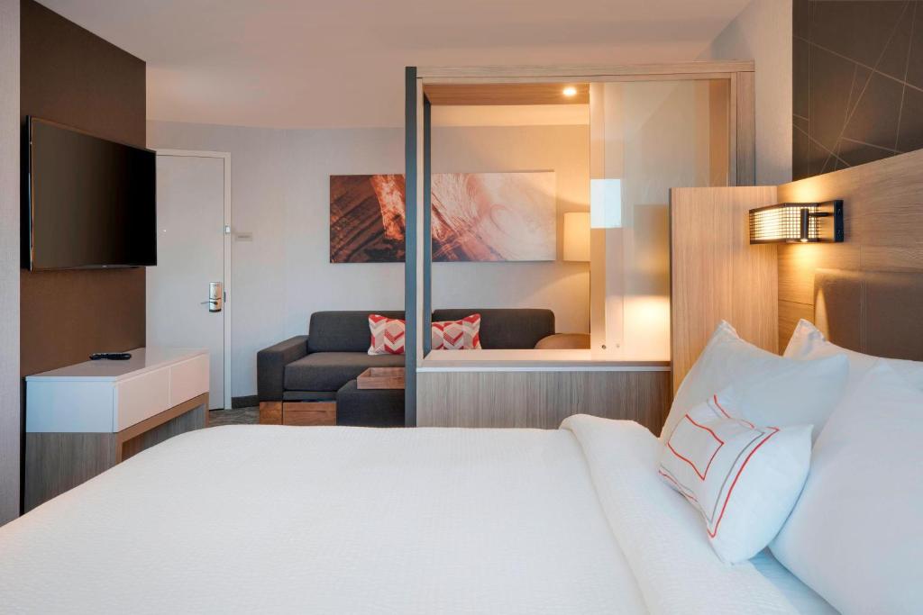 汉普顿SpringHill Suites by Marriott Hampton Portsmouth的酒店客房设有床和客厅。