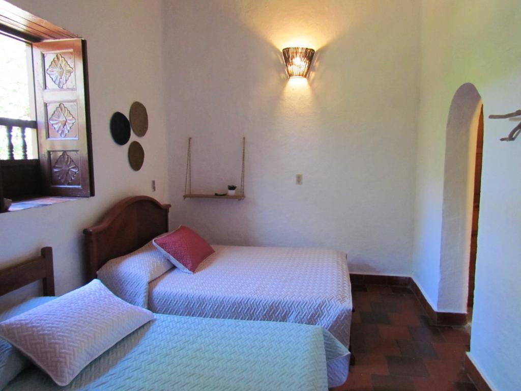 巴里查拉Casa Yerbabuena- Rustiko的一间卧室设有两张床和窗户。