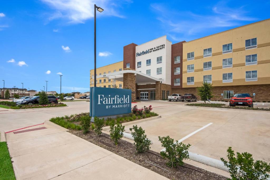 普莱诺Fairfield Inn & Suites by Marriott Dallas Plano/Frisco的停车场上标有标志的酒店 ⁇ 染