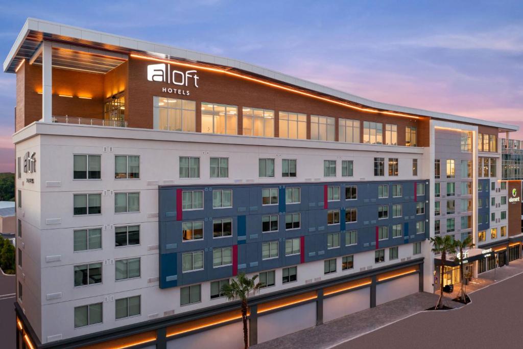 坦帕Aloft Tampa Midtown的公寓大楼的灯光标志