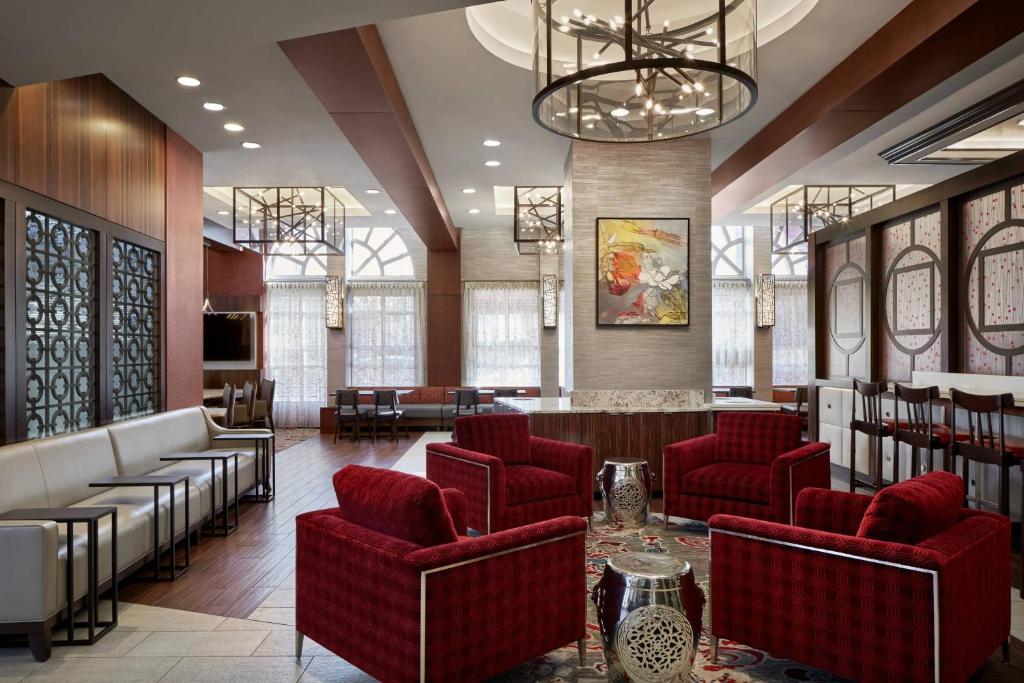 华盛顿华盛顿市中心费尔菲尔德万豪套房酒店的大堂设有红色椅子和酒吧