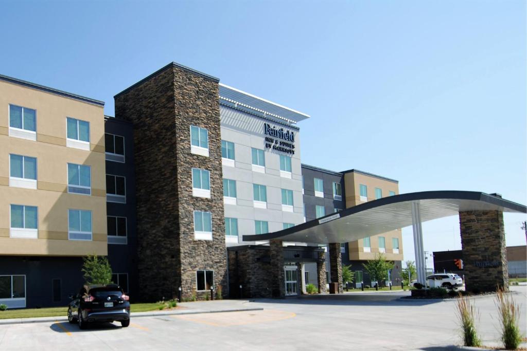 威诺纳Fairfield Inn & Suites Winona的停在大楼前停车场的汽车