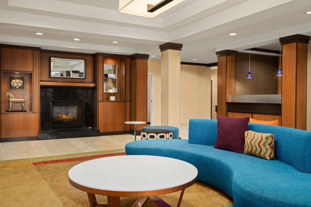 Weirton威尔顿万豪费尔菲尔德客栈&套房酒店的客厅设有蓝色的沙发和壁炉