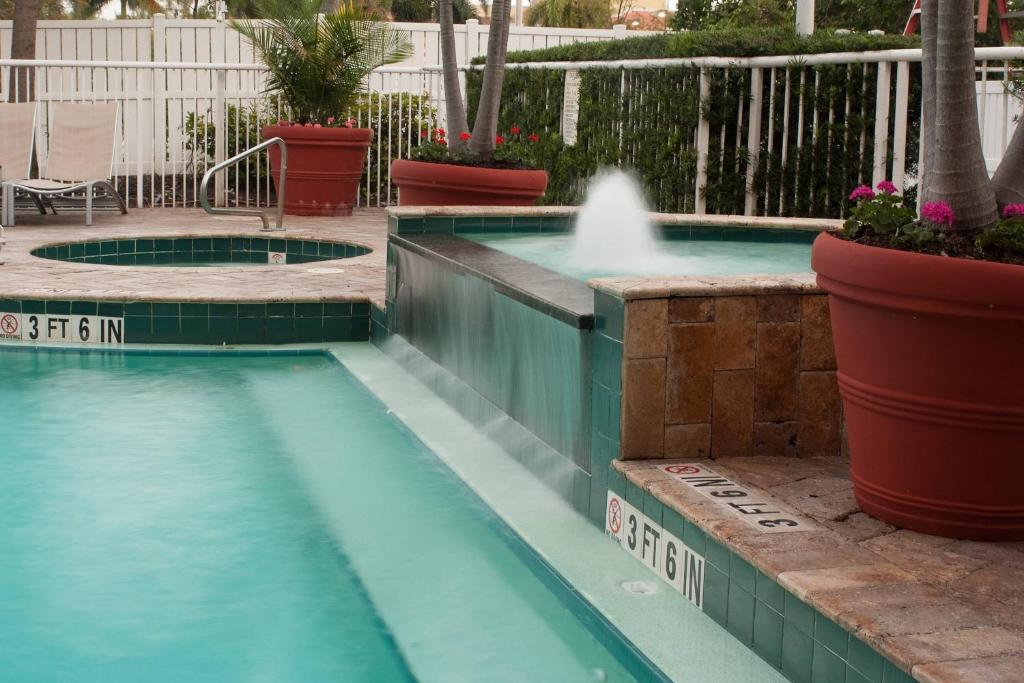达尼亚滩劳德代尔堡机场春季山丘套房酒店的庭院中一个带喷泉的游泳池