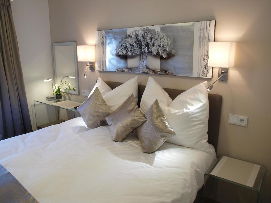 圣沃尔夫冈Lake View Apartment的卧室配有带4个枕头的白色床