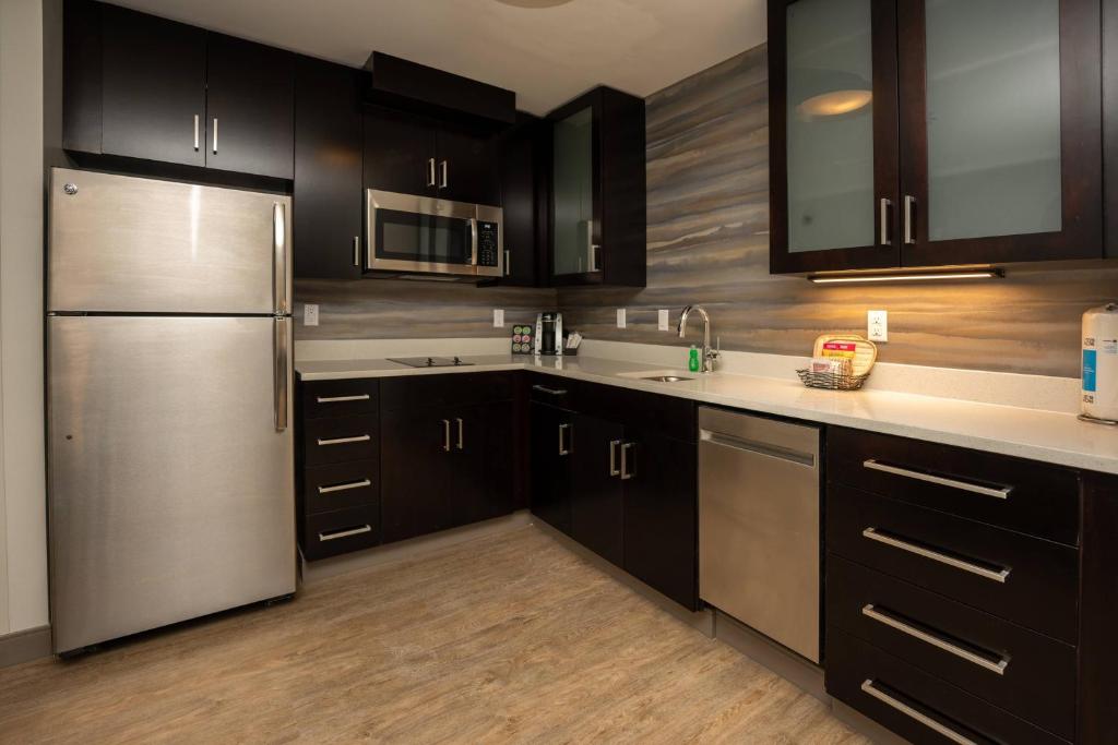 蒙特朱丽叶Residence Inn Nashville Mt. Juliet的厨房配有黑色橱柜和不锈钢冰箱