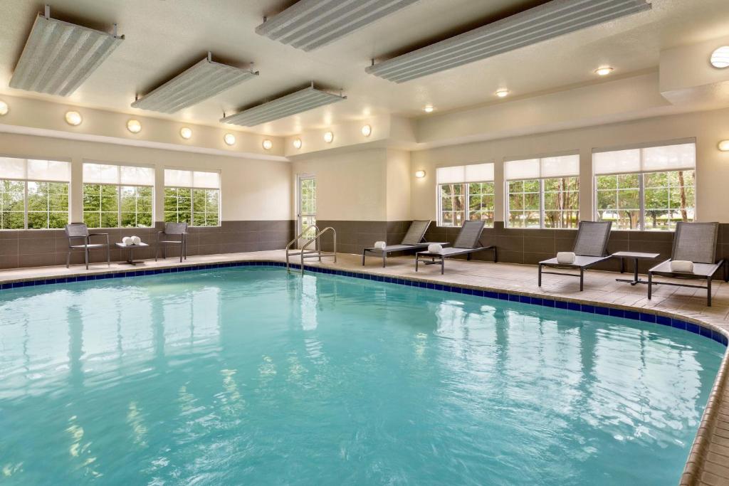 休斯顿休斯顿西北/威洛布鲁克原住客栈的游泳池位于酒店客房内,配有桌椅