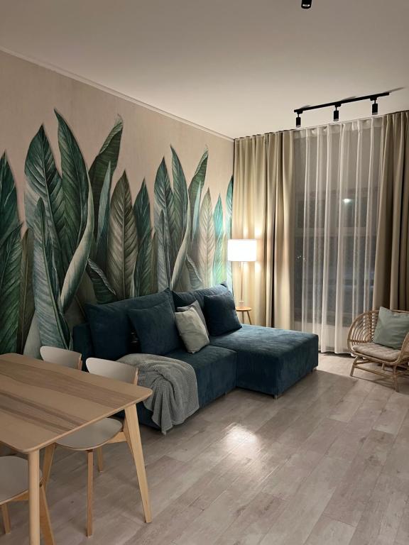 希维拉杜夫-兹德鲁伊Apartament 11 listopada 5的客厅配有蓝色的沙发和木叶壁画