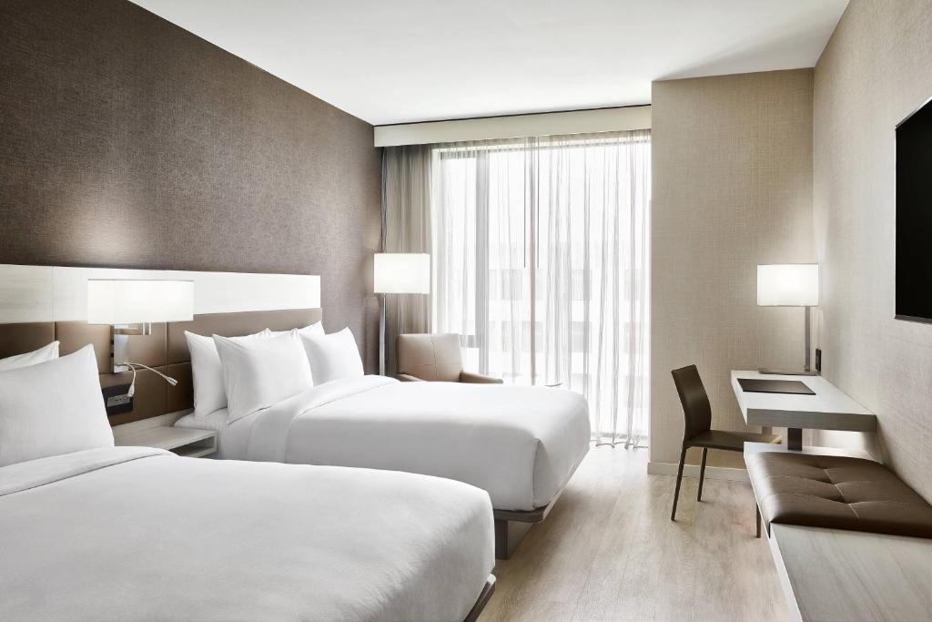 达拉斯AC Hotel By Marriott Dallas By The Galleria的酒店客房配有两张床和一张书桌