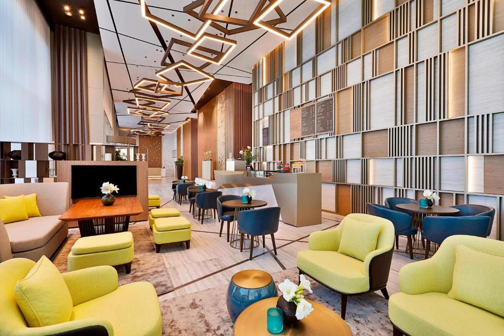 迪拜Courtyard by Marriott Dubai, Al Barsha的大堂配有沙发和椅子。