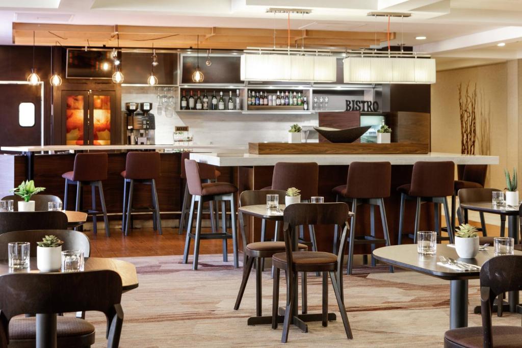 哈里森堡哈里森堡豪庭酒店的一间带桌椅的餐厅和一间酒吧