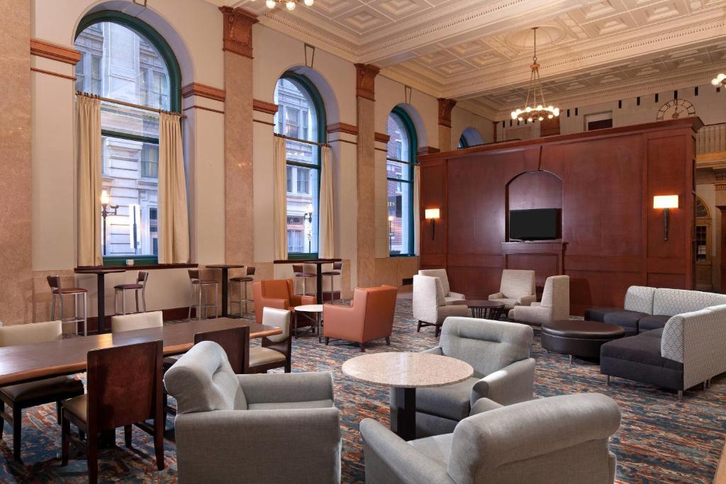 巴尔的摩巴尔的摩市区/内港斯普林希尔万豪套房酒店的大堂设有桌椅和电视。