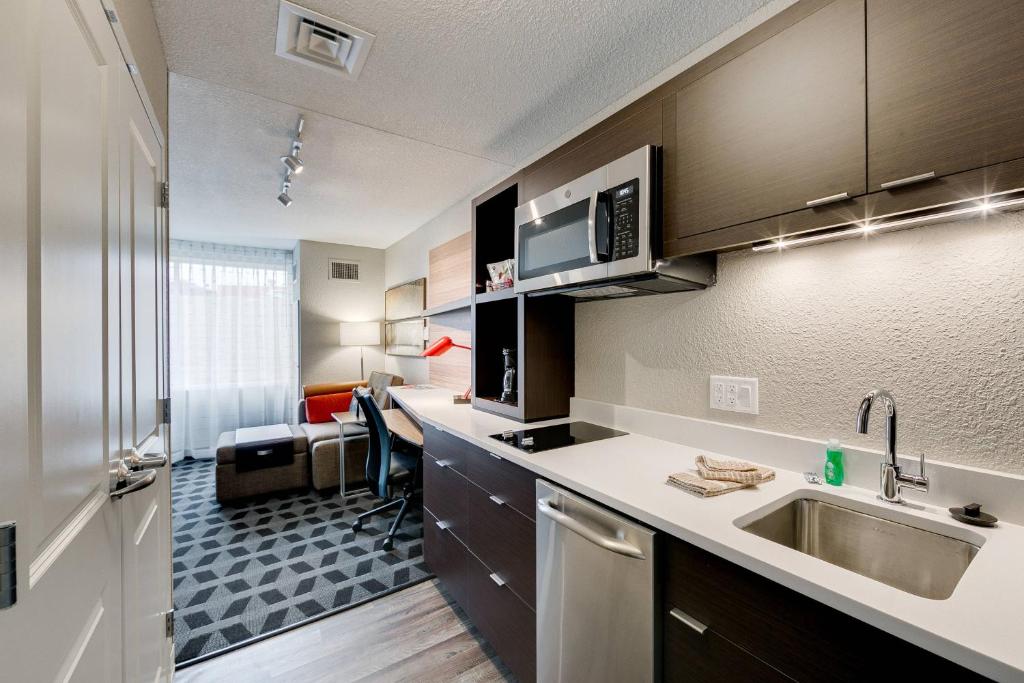 利伯蒂TownePlace Suites by Marriott Kansas City Liberty的公寓的厨房配有水槽和书桌