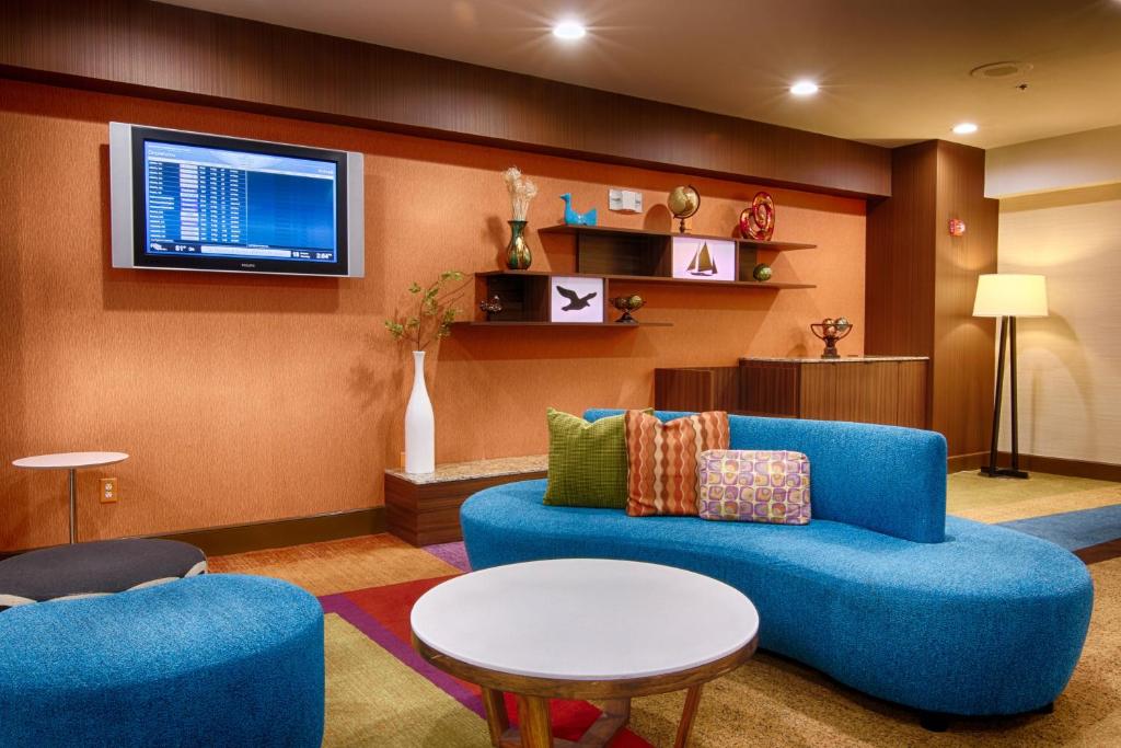 杰克逊维尔费尔菲尔德客栈及套房杰克逊维尔机场酒店的客厅配有蓝色的沙发和电视