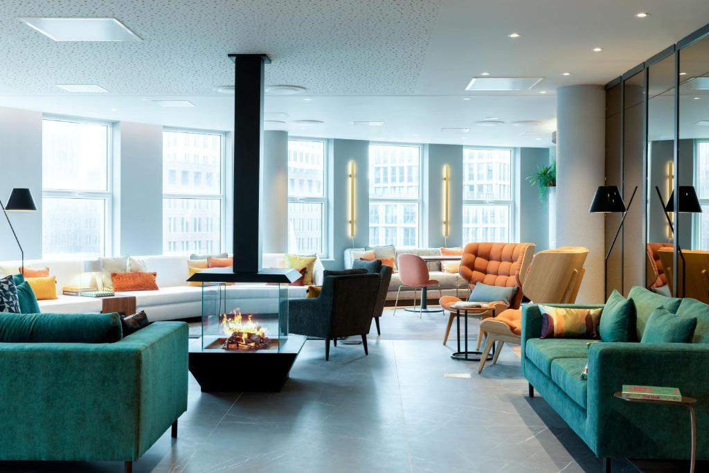 海牙Residence Inn by Marriott The Hague的带沙发和椅子的客厅以及壁炉
