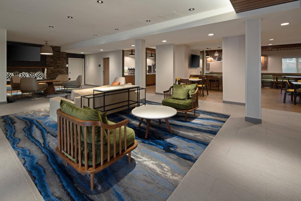 西塔科Fairfield by Marriott Inn & Suites Seattle Sea-Tac Airport的大堂设有桌椅,铺着地毯