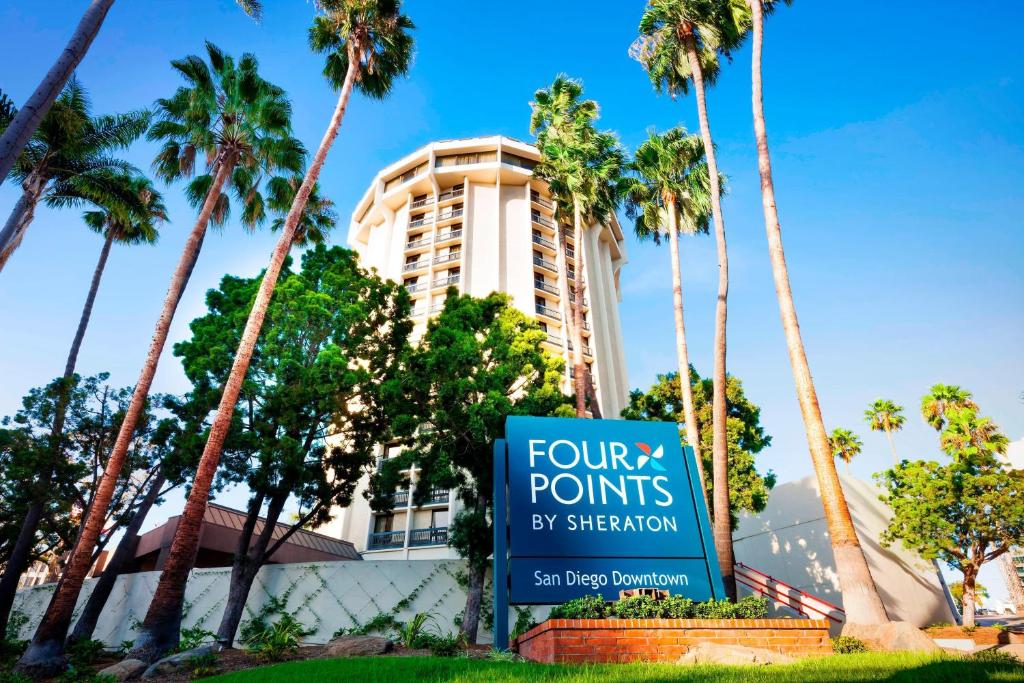 圣地亚哥圣地亚哥市中心小意大利福朋喜来登酒店 的棕榈树建筑前的标志