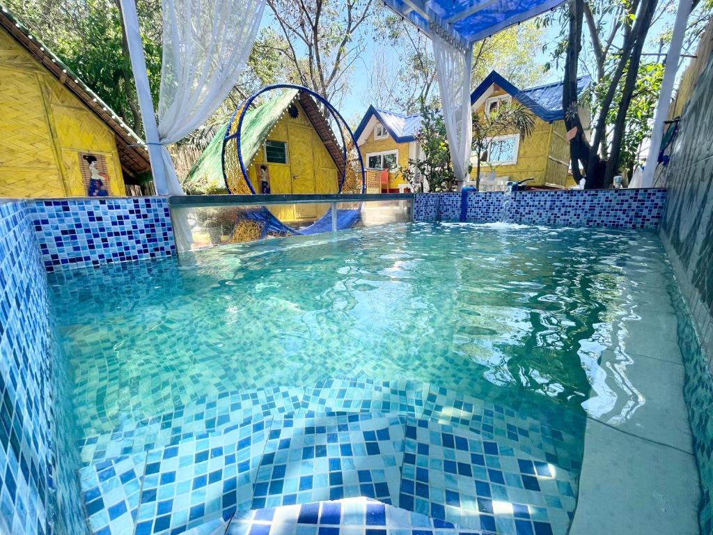 LingayenBeachfront Glamping with Mini Pool Exclusive Property的水面上蓝色瓷砖的游泳池