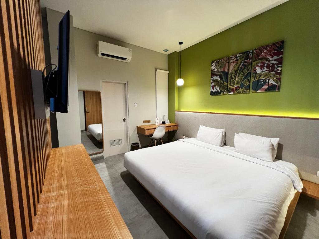 雅加达CASA CALMA HOTEL的卧室配有白色的床和绿色的墙壁
