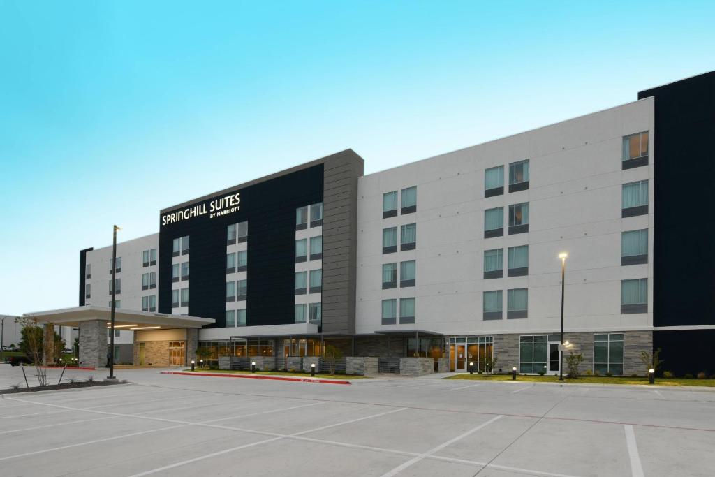 沃思堡SpringHill Suites Dallas DFW Airport South/CentrePort的前面有停车位的大楼