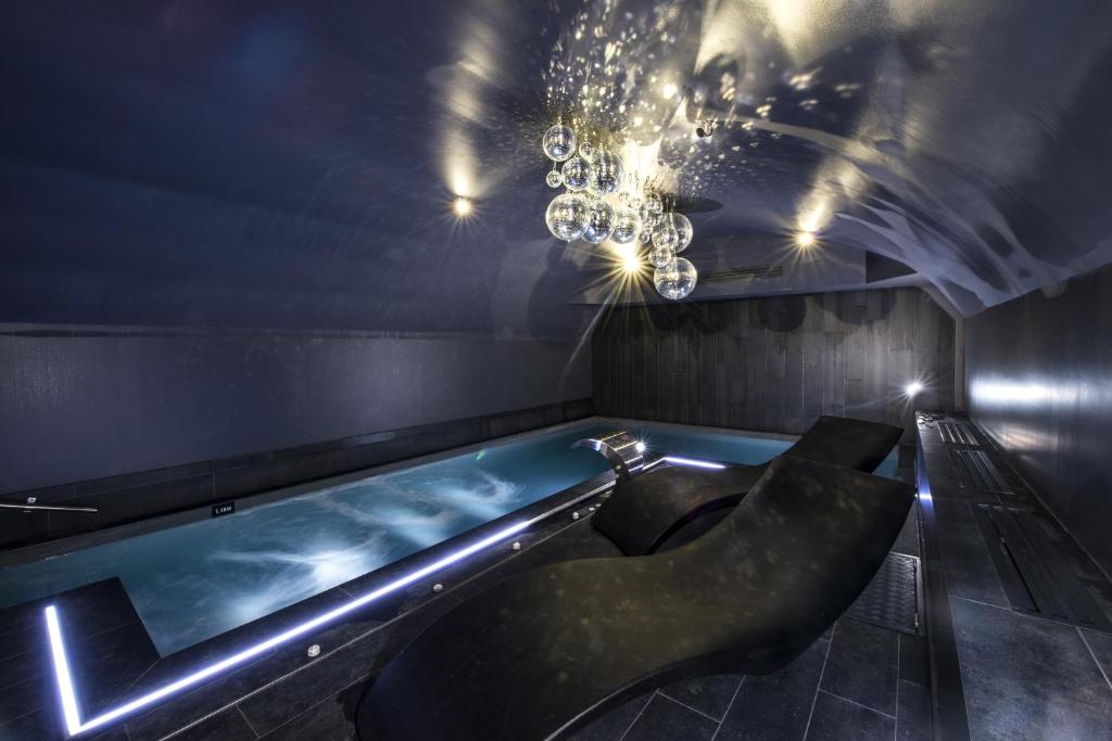 第戎Vertigo Hotel, Dijon, a Member of Design Hotels的配有吊灯的客房内的浴缸