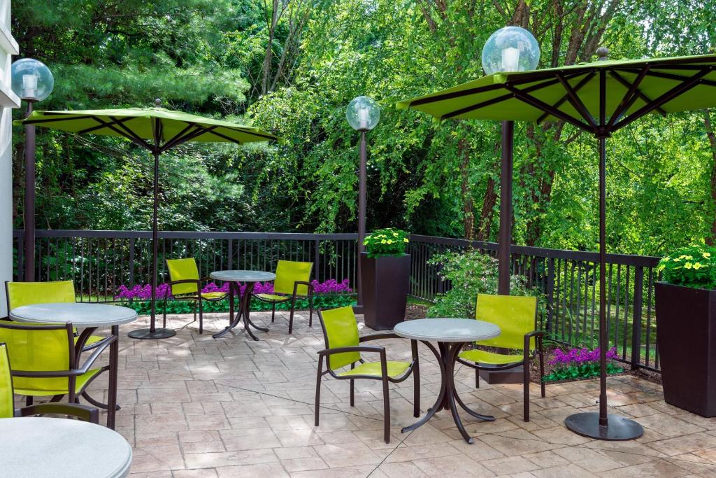 阿什维尔阿什维尔春季山丘套房酒店的一个带桌椅和遮阳伞的庭院