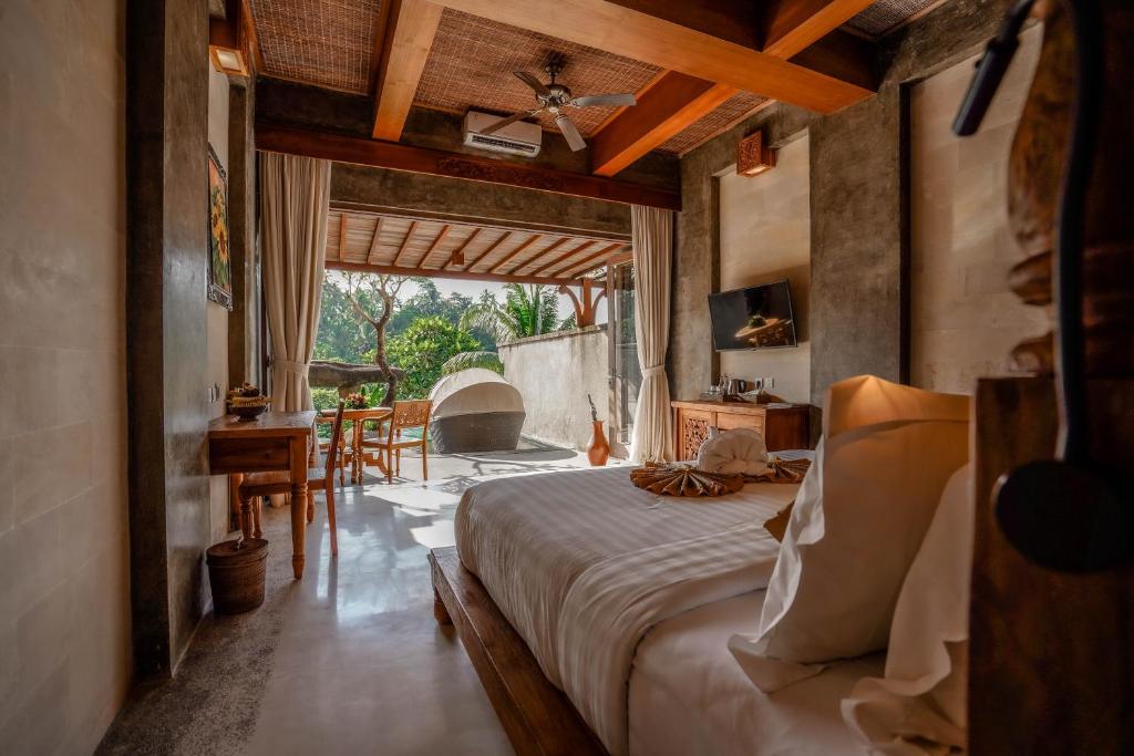 乌布Kastara Resort的一间卧室配有一张床、一张桌子和一个壁炉