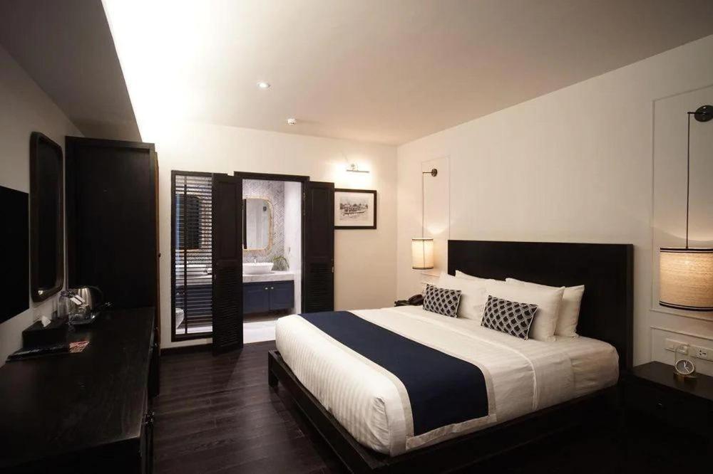 清迈奇瓦迪酒店的一间带大床的卧室和一间浴室