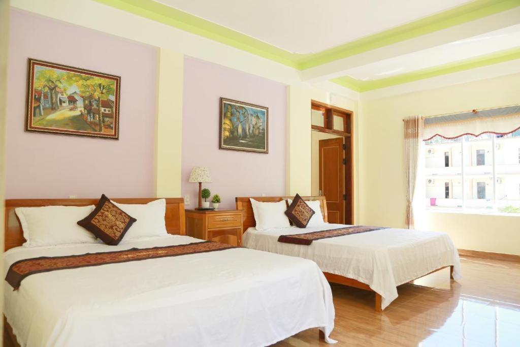 峰牙Phong Nha Midtown hotel的一间卧室设有两张床和窗户。