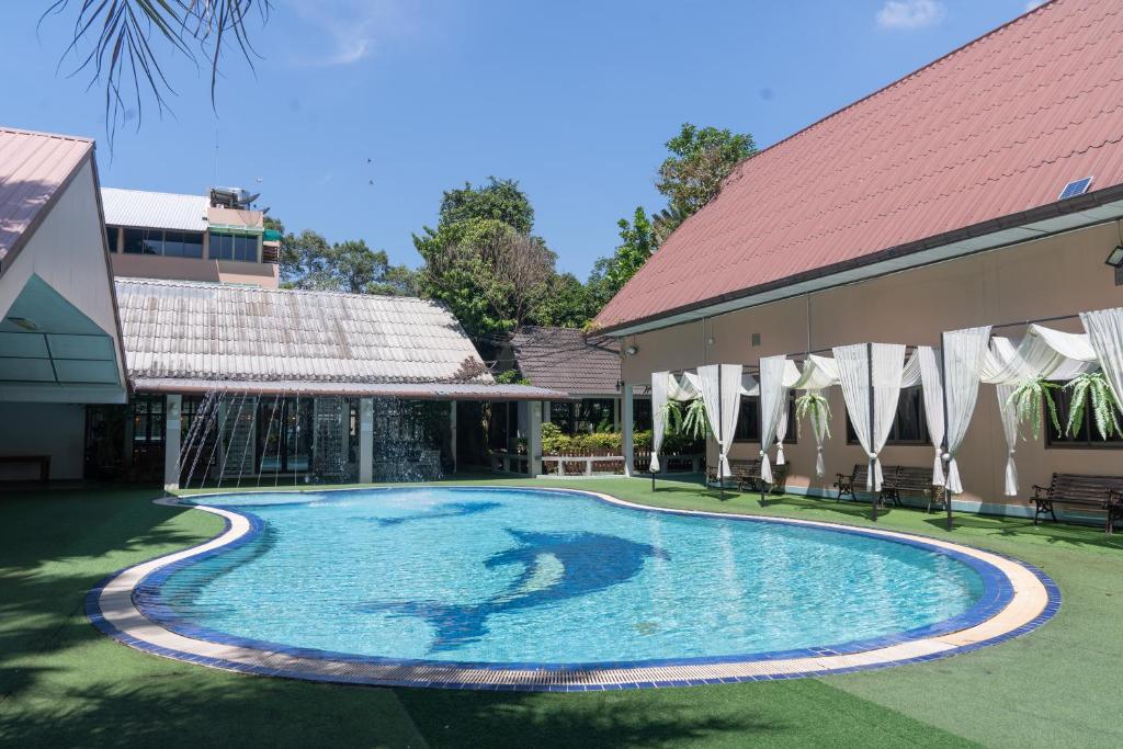 坤西育府บ้านนารีสอร์ท的一座游泳池,位于一座建筑旁的院子内