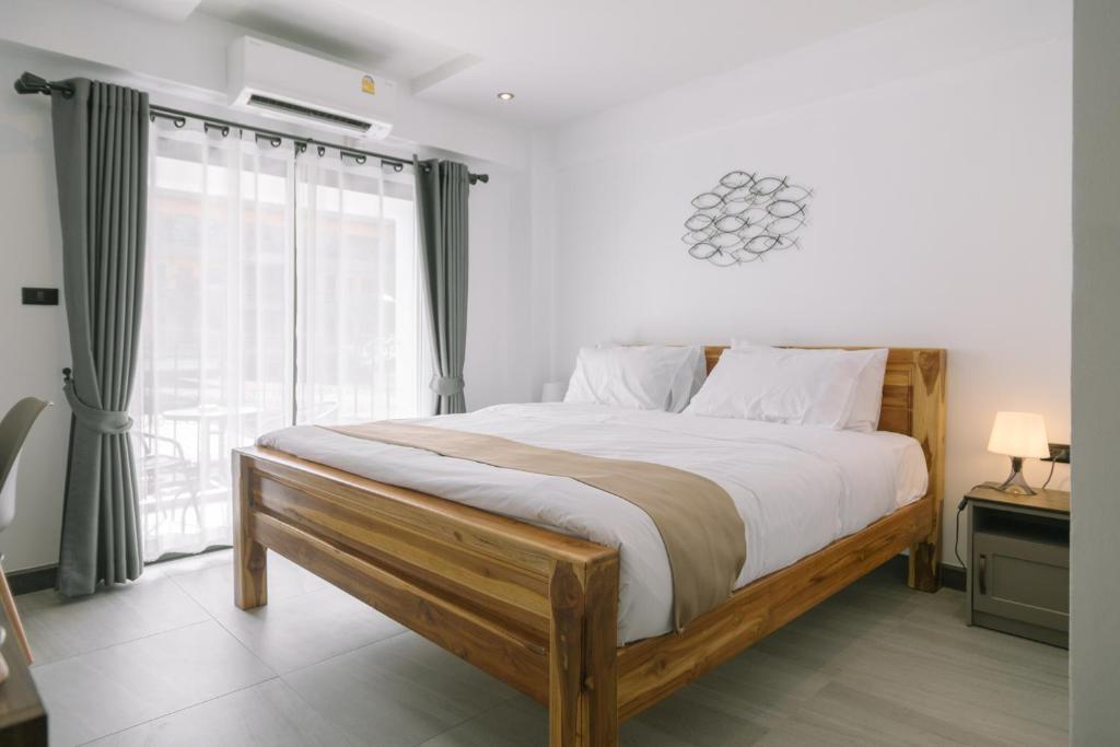 芭堤雅市中心ONE LODGE Pattaya的一间卧室设有一张大床和一个窗户。
