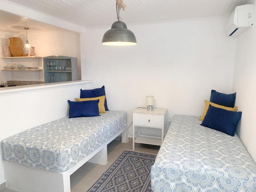 斯基亚索斯镇The Guest House的两张床铺,配有蓝色和黄色枕头