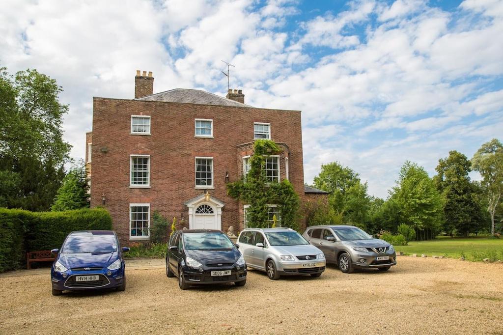 SetcheyThe Grange Manor House, Norfolk的停在房子前面的三辆车